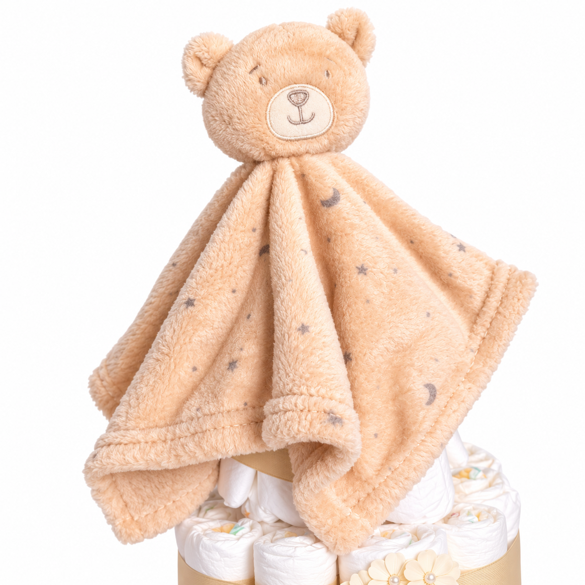 Beiges Teddy-Schmusetuch mit Mond-und-Sterne-Muster auf einer Windeltorte